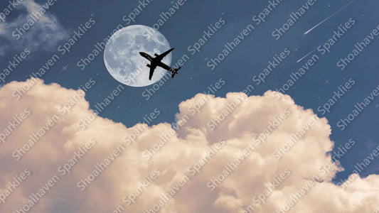 A plane flies across the night sky with a moon and stars